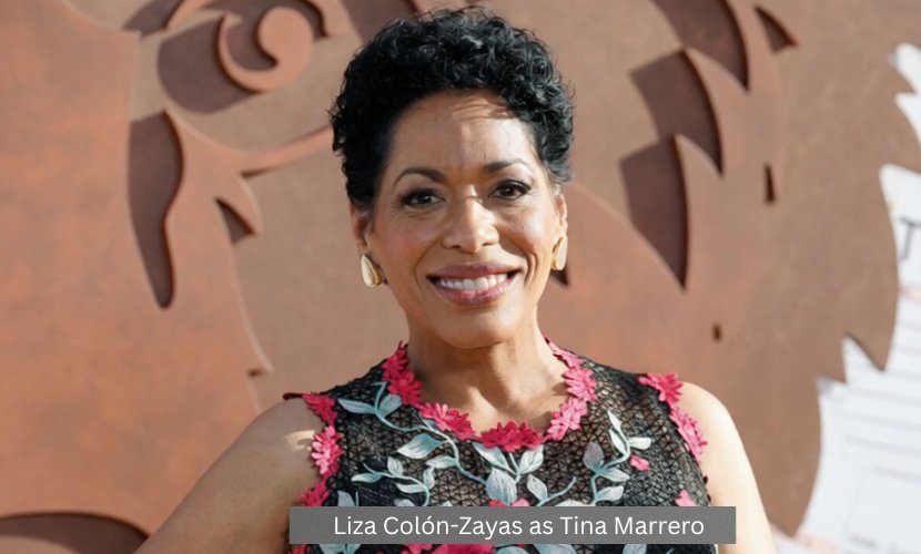 Liza Colón-Zayas attends a promotional event for The Bear, wearing a floral-patterned dress and smiling for photographers.