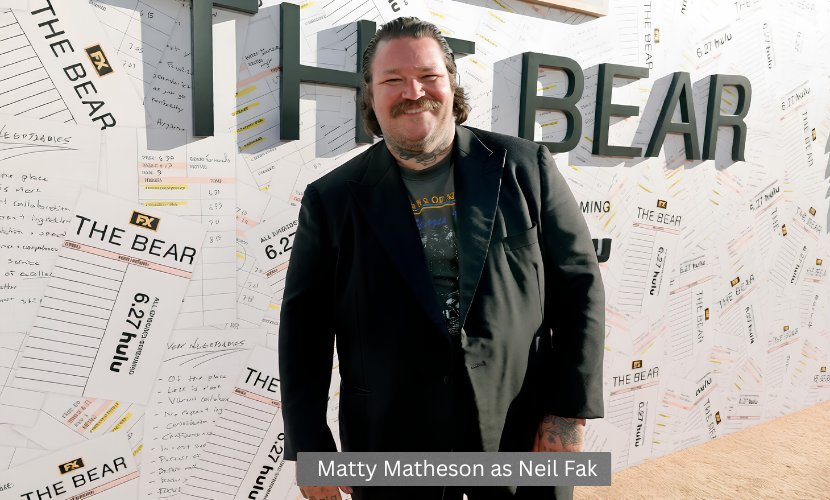 Matty Matheson poses at The Bear premiere event in front of the show's promotional backdrop.